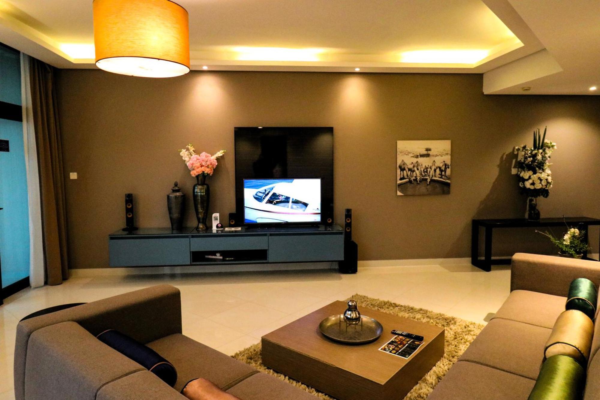 Lagoona Beach Luxury Resort And Spa Manama Luaran gambar The photo shows a modern living room with a neutral color palette. Key features include:

- A comfortable seating area with a sofa arranged around a coffee table.
- A minimalist coffee table with a decorative item on top.
- A large flat-screen televi